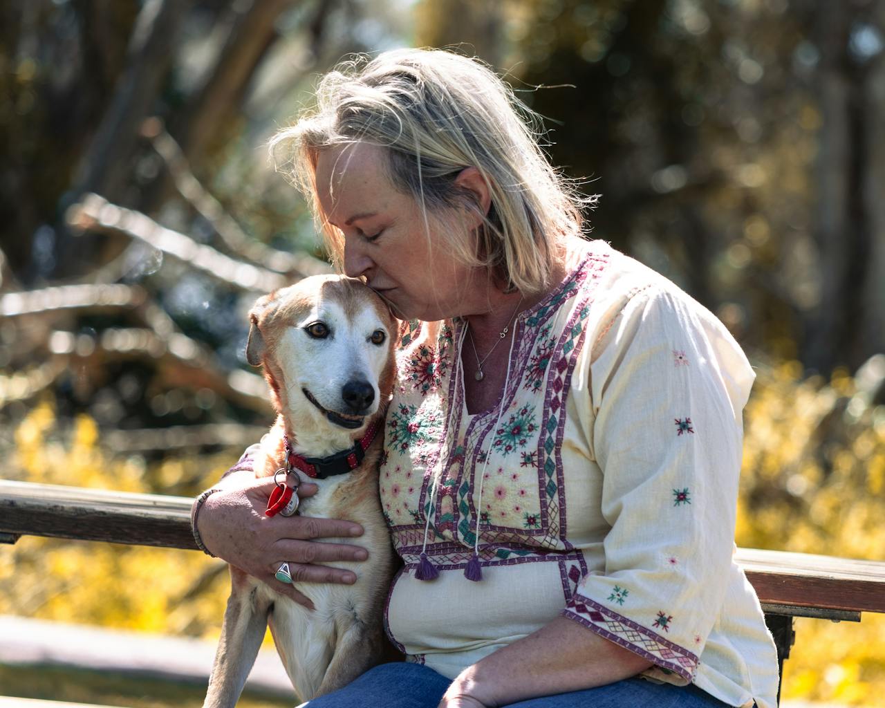 A tender moment as a woman embraces her dog outdoors in Bibra Lake, Australia.